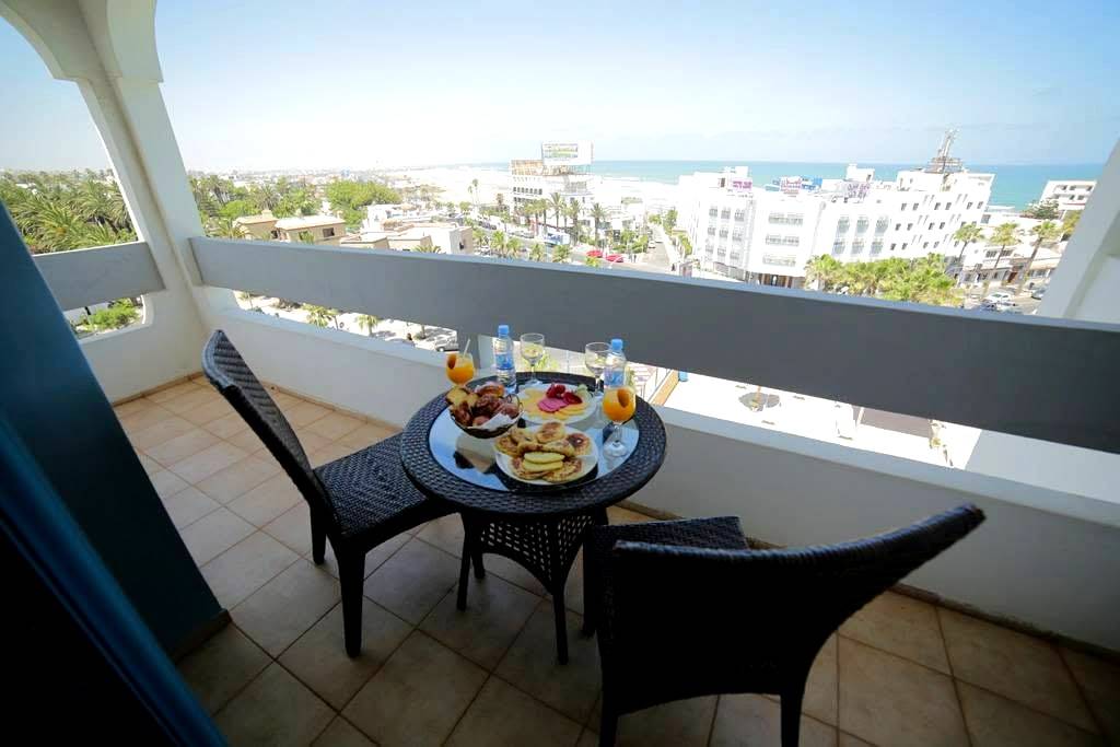 Petit-déjeuner sur un balcon côté boulevard, l'Atlantique à l'horizon